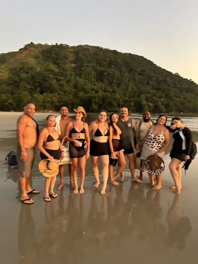 Grupo de passageiros reunido na areia, no fim do passeio.