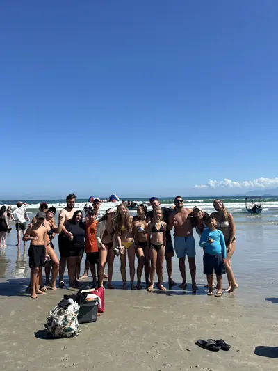 Grupo na beira da praia, com a água pela canela.